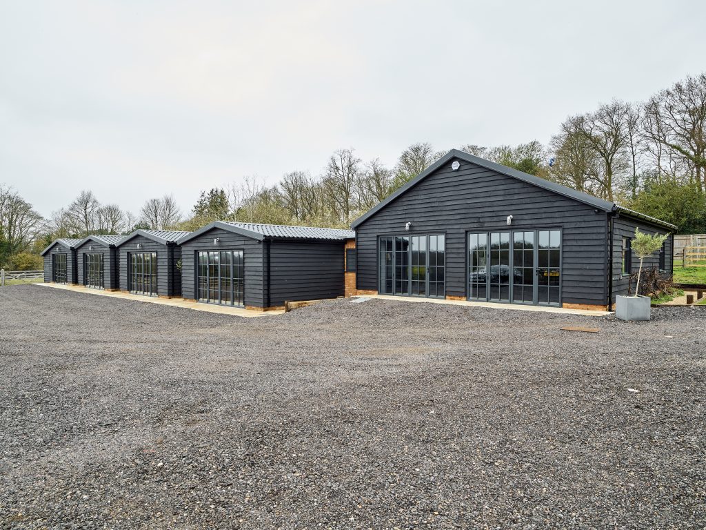 The Griffin project - luxury garage - luxury cars - 5 connected barns - grey wood exterior -self build